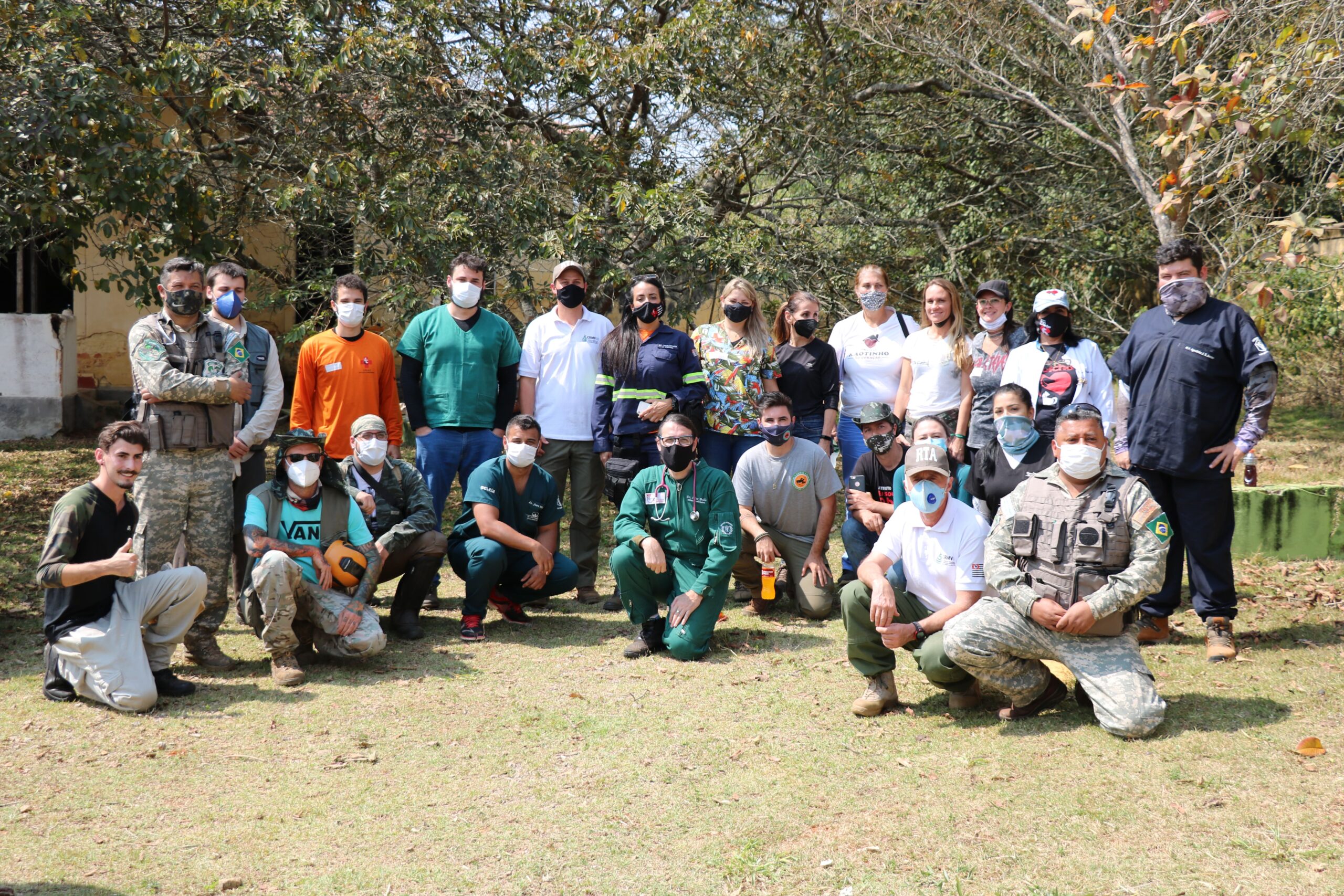 Voluntários médicos-veterinários, zootecnistas, biólogos e auxiliares posam em frente a árvores