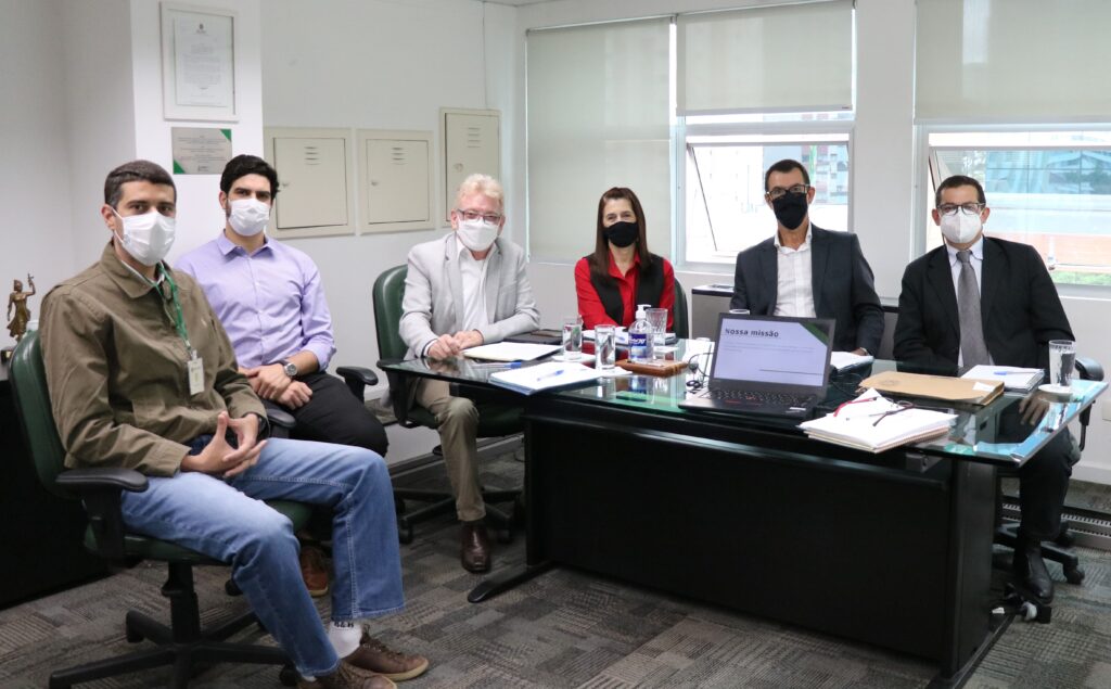 Diretores e assessores do CRMV-SP estão de máscara, olhando para a câmera, sentados ao entorno de uma mesa com cadernos e computadores. Na foto está também o presidente escolhido para a Comissão de Representantes Regionais.