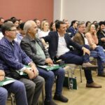 A imagem tem como foco o auditório lotado durante o CRMV-SP Escuta. Ao centro da foto aparece também sorrindo o presidente da Ammvet. No canto direto da foto estão presidentes de comissões técnicas do CRMV-SP e representantes regionais.