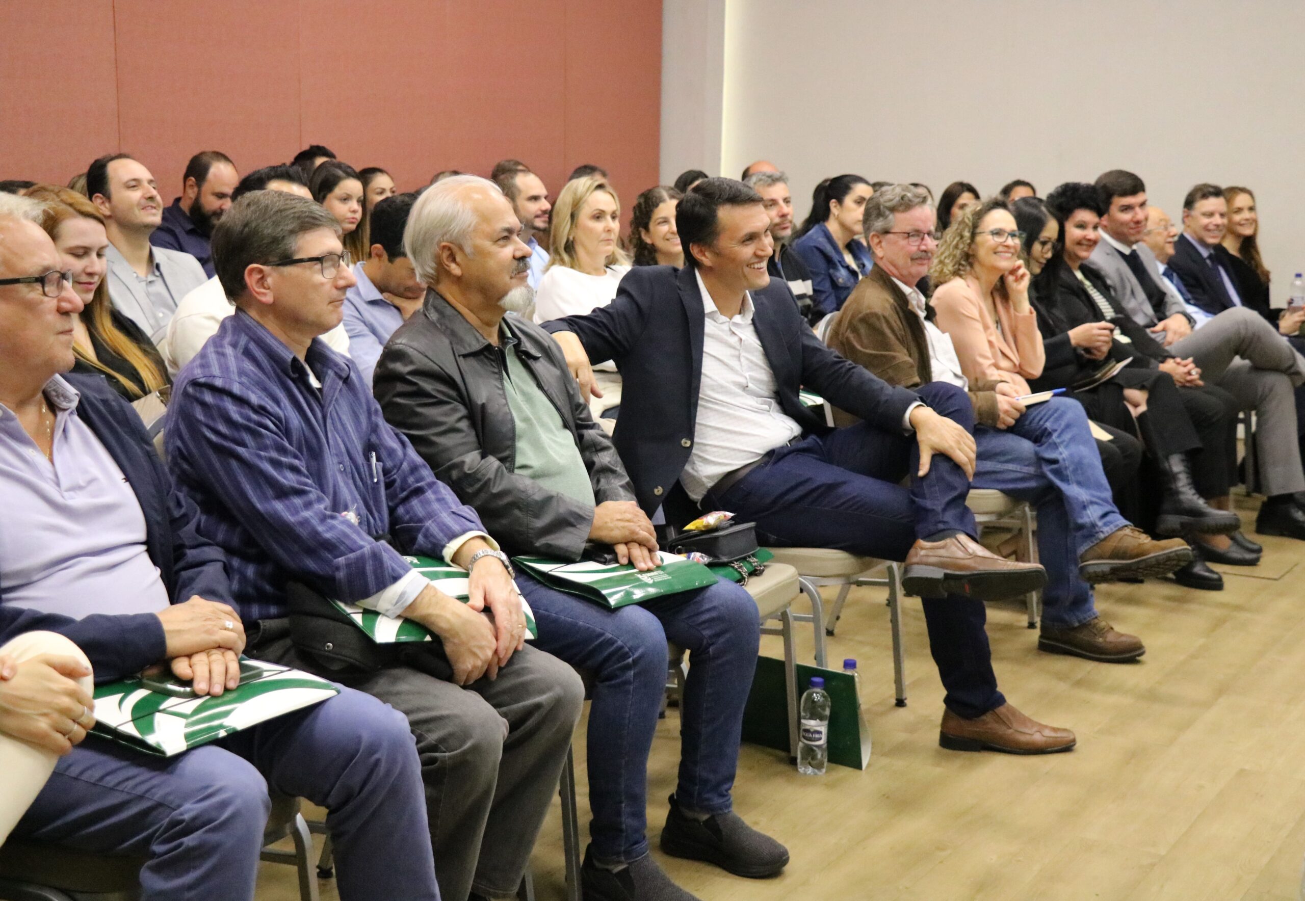 A imagem tem como foco o auditório lotado durante o CRMV-SP Escuta. Ao centro da foto aparece também sorrindo o presidente da Ammvet. No canto direto da foto estão presidentes de comissões técnicas do CRMV-SP e representantes regionais.