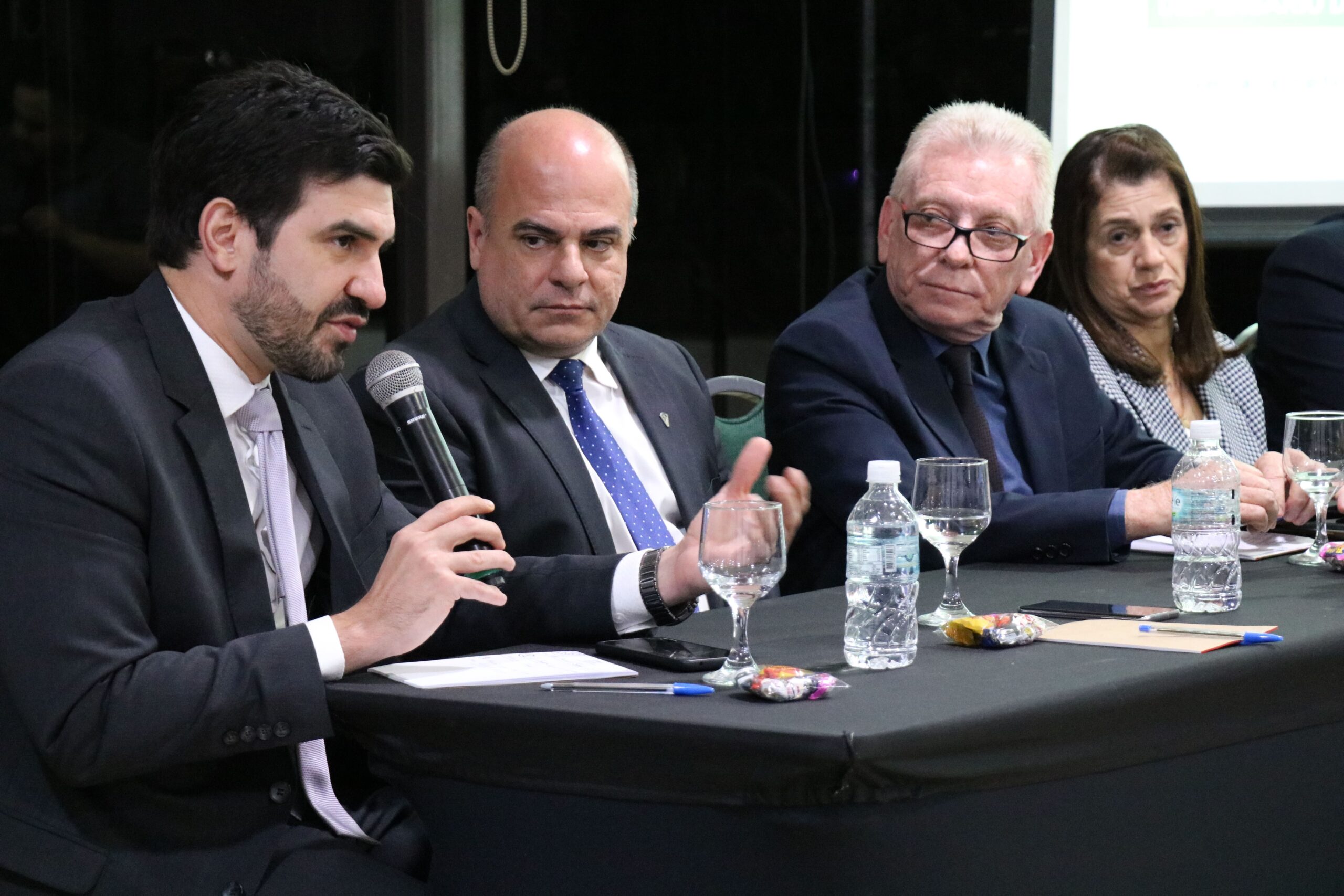 Na foto está a diretoria do CRMV-SP sentada à mesa. O Assessor Jurídico Bruno Fassoni Está com microfone na mão falando sobre as decisões judiciais da Medicina Veterinária