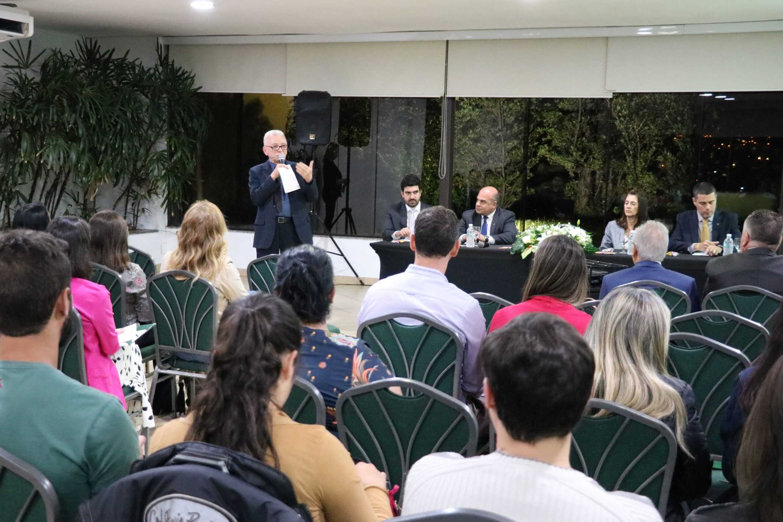 Na foto há a diretoria do CRMV-SP, o Presidente em pé palestrando para um auditório