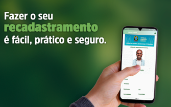 Na imagem aparece a mão de uma pessoa segurando um celular com a tela do aplicativo da cédula digital de identidade profissional. Há ainda os dizeres: Fazer o seu recadastramento é fácil, prático e seguro. O fundo da imagem é todo verde escuro.