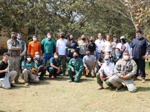 Voluntários médicos-veterinários, zootecnistas, biólogos e auxiliares posam em frente a árvores