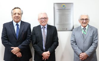 A foto mostra os três presidentes do CRMV-SP, da atual gestão e das gestões anteriores, ao lado da placa do CRMV-SP.