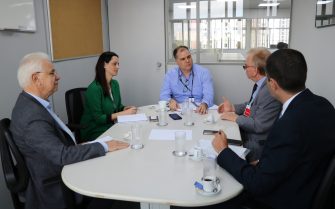 Na foto aparecem sentados ao entorno de uma mesa oval cinza, os representantes do CRMV-SP, a coordenadora de fauna silvestre e o subsecretário. Estão todos conversando e o subsecretário está na cabeceira da mesa.